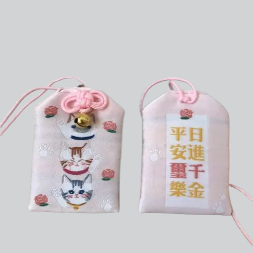 Pochettes japonaises omamori (porte-bonheur) avec des motifs de chats et des caractères chinois.