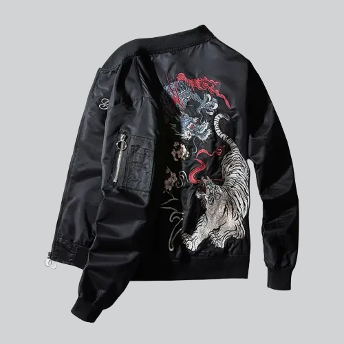 Blouson bombardier noir orné d’un motif brodé de tigres et de dragons blancs avec des accents rouges.