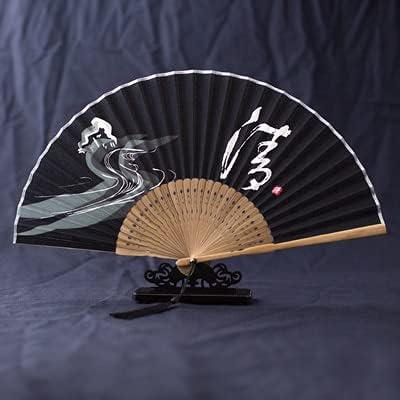 Eventail pliant traditionnel japonais en tissu noir avec calligraphie blanche et motifs de vagues.