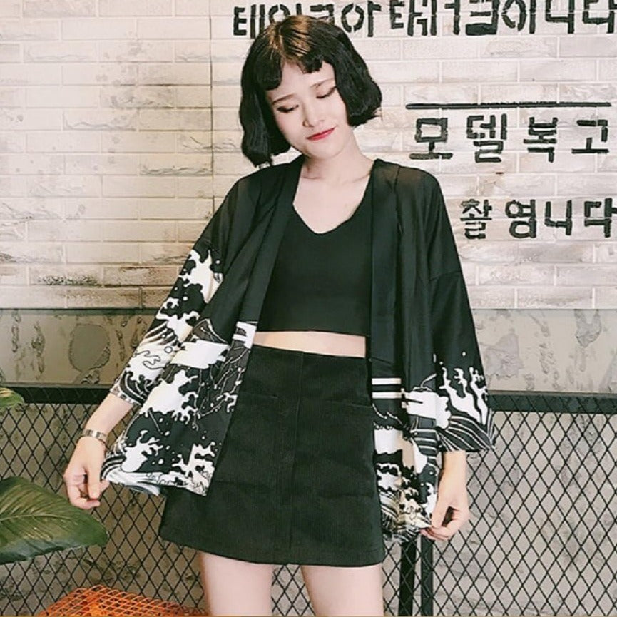 Un cardigan de style kimono à fleurs noires et blanches porté avec un ensemble crop top et jupe assortis.