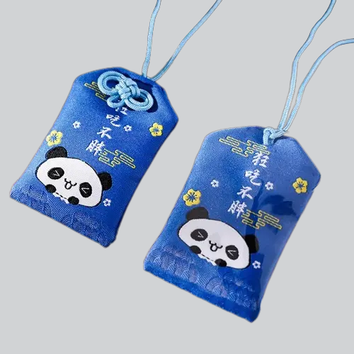 Deux pochettes d’amulettes en tissu bleu décorées de mignons visages de panda et de fleurs jaunes.