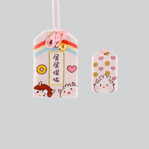 Breloque décorative japonaise omamori rose avec de jolies illustrations et des rayures arc-en-ciel.