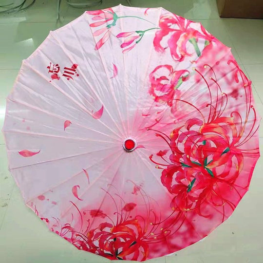 Parasol en papier blanc décoré de motifs floraux roses.