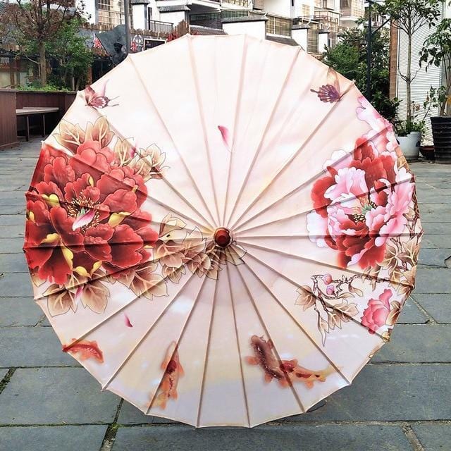 Parasol traditionnel chinois en papier décoré de motifs floraux rouges et roses.