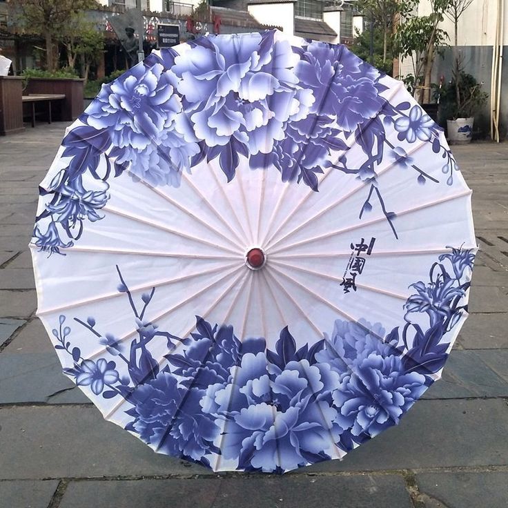 Parasol traditionnel en papier décoré de motifs floraux bleus et blancs.